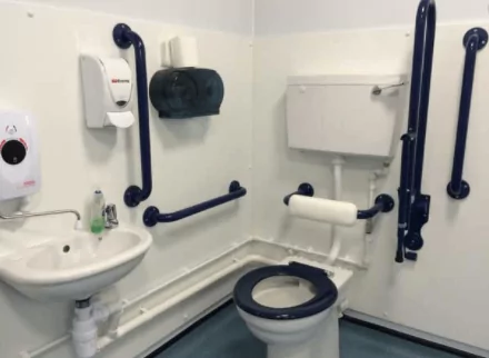 An accessible restroom with multiple grab bars.