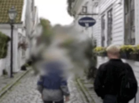 Two people walking on the street the center being very blurred.