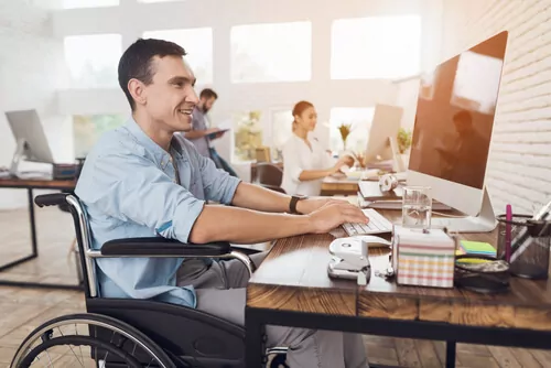 A man in a wheel chair using a computer.